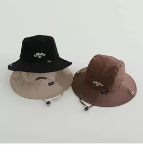 Detailansicht der Kinder-Sonnenhüte in Schwarz und Khaki mit Lucky-Stickerei und Kordel