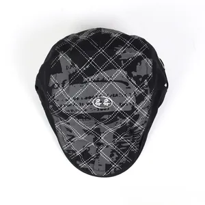 Vue détaillée d'une casquette gavroche blanche à carreaux avec imprimé graffiti et logo