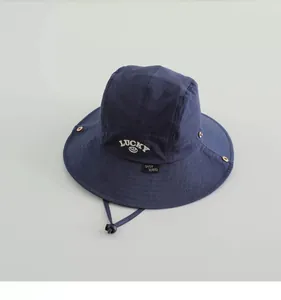 Detail eines navy Sonnenhuts mit weißem LUCKY Stickerei und verstellbarem Windseil