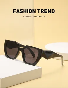 Detail view of black cat-eye sunglasses with thick geometric temples on a white pedestal