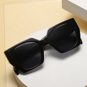 Chic black cat-eye sunglasses with wide temples on a minimalist geometric white pedestal