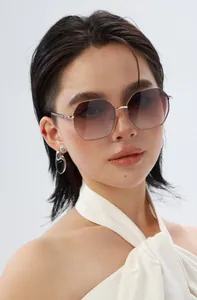 Femme portant des lunettes de soleil octogonales en métal avec verres dégradés violets