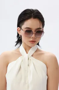 Détail de lunettes de soleil polygonales en métal avec verres dégradés violets sur modèle