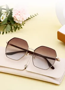 Gros plan sur des lunettes de soleil carrées en métal avec verres dégradés et étui