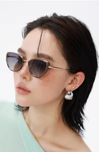 Close-up of cat-eye sunglasses featuring tortoiseshell frames and gradient lenses on a model