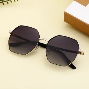 Lunettes de soleil polygonales avec monture dorée et verres dégradés gris