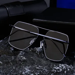 Détail de la monture en métal argenté et verres polarisés gris foncé des lunettes carrées