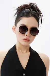 Close-up of model wearing large round polarized sunglasses with gradient brown lenses