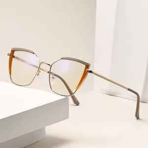 Modern cat-eye metal eyeglasses with amber accents on a minimalist geometric stand