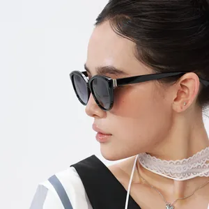 Detail of wide black frame sunglasses with subtle metal accents on the temple hinges