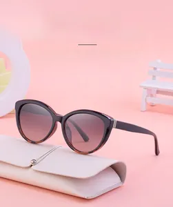Close-up of cat-eye polarized sunglasses with gradient frame and white leather pouch