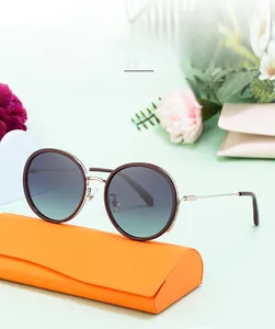 Close-up of trendy round polarized sunglasses with lightweight TR frame and orange case