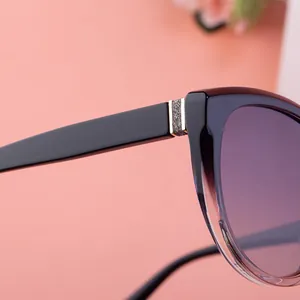 Detail of a cat-eye sunglass hinge with silver glitter metal and purple gradient frame