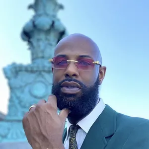 Detail of luxury rimless sunglasses with gold hardware and pink gradient lenses on model