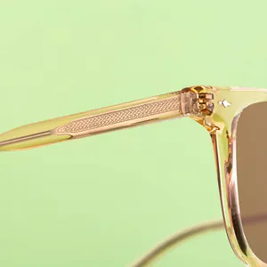 Macro detail of champagne square sunglasses featuring metal core temples and diamond rivets