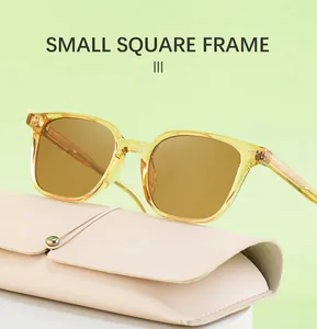 Detail of small square sunglasses with transparent yellow frame and brown lenses