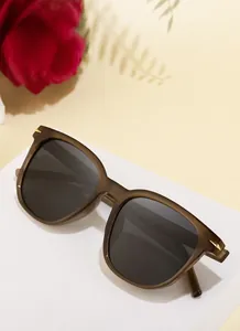 Detail view of TR90 square frame sunglasses with golden arrow metal accents on corners