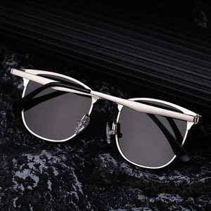Détail de lunettes de soleil demi-cerclées avec monture dorée sur pierres sombres