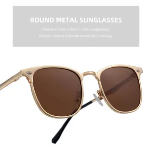 Détail de lunettes de soleil rondes en métal doré mat avec des verres marron