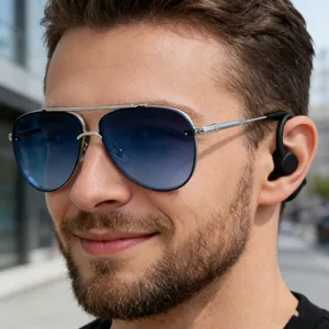 Close-up of pilot sunglasses with blue gradient lenses and wireless earphone worn by male model