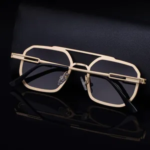 Detailed view of square metal sunglasses with golden double-bridge frame on leather