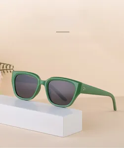 Gros plan des lunettes de soleil polarisées TR90 vertes sur un présentoir blanc