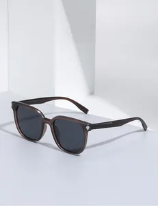 Détail de lunettes de soleil carrées avec monture marron translucide et décorations croix