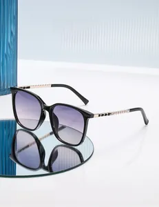 Detail of square sunglasses with purple gradient lenses and gold pearl chain temples