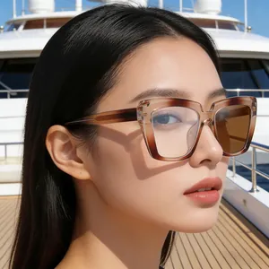 Occhiali da sole cat-eye sfumati marroni indossati sul ponte di uno yacht di lusso