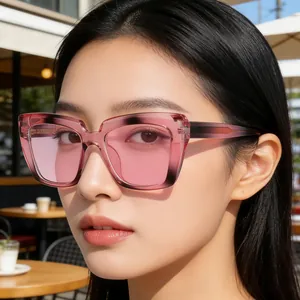 Primo piano di occhiali da sole cat-eye rosa con montatura trasparente su una modella