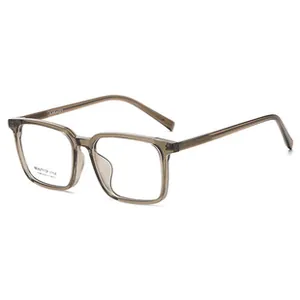 Close-up of translucent grey square eyeglass frames with detailed metal hinge and branding