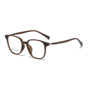 Detail view of square dark brown eyeglasses frame with metal hinges and transparent lens