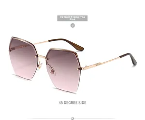 Detail view of gold rimless sunglasses with pink gradient diamond cut lenses