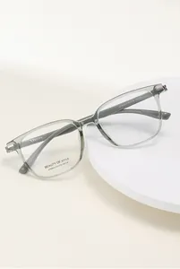 Close-up of olive green square optical frames showing spring hinges and polished finish