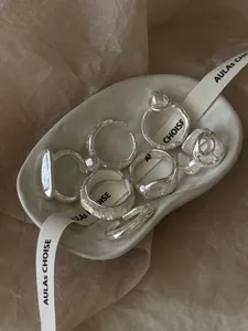 Détails de bagues en argent avec texture artisanale irrégulière sur assiette en céramique