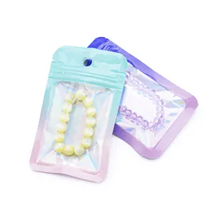 Detail of gradient holographic jewelry bags containing yellow and purple beaded bracelets