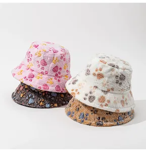 Detail von vier Plüsch-Anglerhüten mit bunten Pfotenabdrücken in Rosa, Weiß, Schwarz und Braun