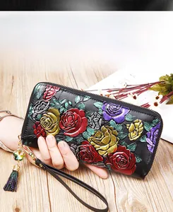 Close-up of a black leather wallet with colorful 3D embossed floral patterns and tassels