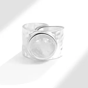 Minimalist silver open ring with irregular hammered texture and round metal disc decoration