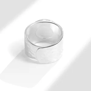 Minimalist hammered silver ring with irregular textured surface and open wrap design