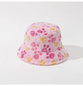 Detail eines weichen rosa Anglerhuts aus Plüsch mit bunten Pfotenabdrücken für den Winter
