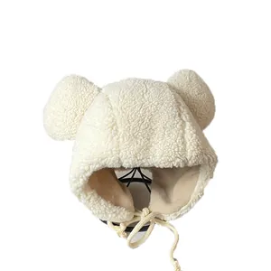 Creamy white fleece earflap hat with cute bear ears and woven drawstrings for winter warmth