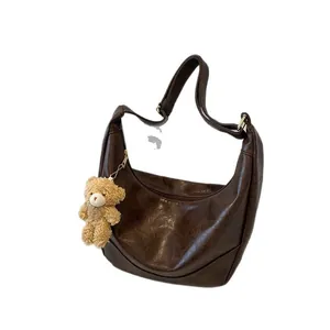 Retro dark brown crescent shoulder bag in glossy PU leather with a cute plush bear charm