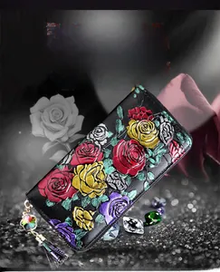 Macro view of 3D embossed rose pattern and tassel charm on long leather wallet