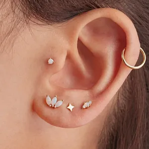 Set of gold s925 silver opal studs in star and clover shapes on model ear