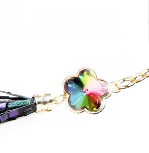 Detailed close-up of rainbow crystal flower zipper pull with gold tassels and chain