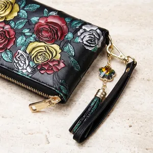 Détail du portefeuille en cuir gaufré avec dragonne et pendentif fleur en cristal