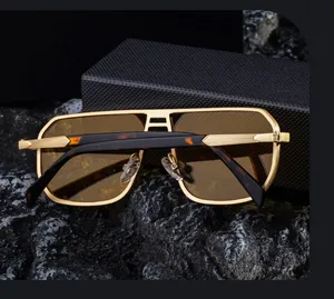 Detalle de gafas aviador de metal dorado con doble puente y funda estilo carbono