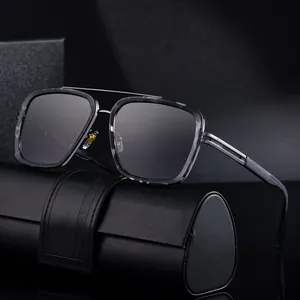 Lunettes de soleil carrées modernes avec verres dégradés et monture grise sur étui cuir