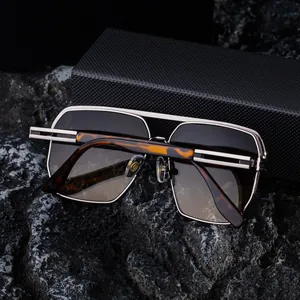 Detailansicht der goldenen Doppelsteg-Sonnenbrille auf schwarzem strukturiertem Felsen